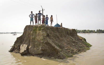 Flood affected villagers wait for relief material on a broken road washed away by floodwaters in Morigaon district, east of Gauhati, northeastern state of Assam.