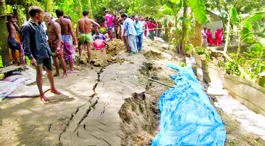 Cracks developed on the flood protection dams at Shariakandi area due to onrush of flood water. Photo shows local people trying hard to repair the damaged side of the flood control dam on Thursday.