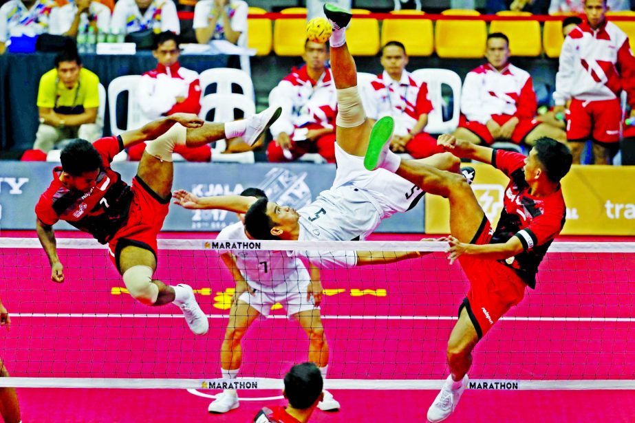 Thailand's Pornchai Kaokaew (center) kicks a ball against Indonesia's Saiful Rijai (left) and Syamsul Hadi during the men's Sepak Takraw Regu competition at South East Asian Games in Kuala Lumpur, Malaysia on Friday.