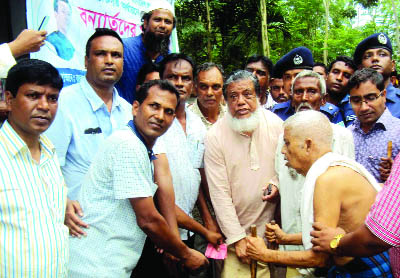 SAGHATA(Gaibandha): Deputy Speaker of Jatiya Sangsad Adv Fazley Rabbi Miah MP distributing relief goods among the flood- hit people at Manikganj Bazar recently.