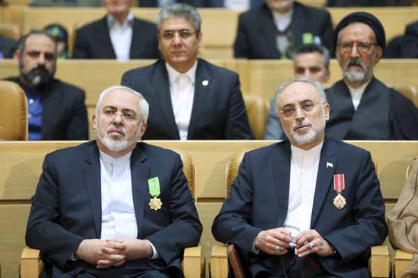Chief of Iran's Atomic Energy Organization Ali Akbar Salehi, right, sits next to Foreign Minister Mohammad Javad Zarif after being awarded medal of honor by President Hassan Rouhani during a ceremony in Tehran, Iran.