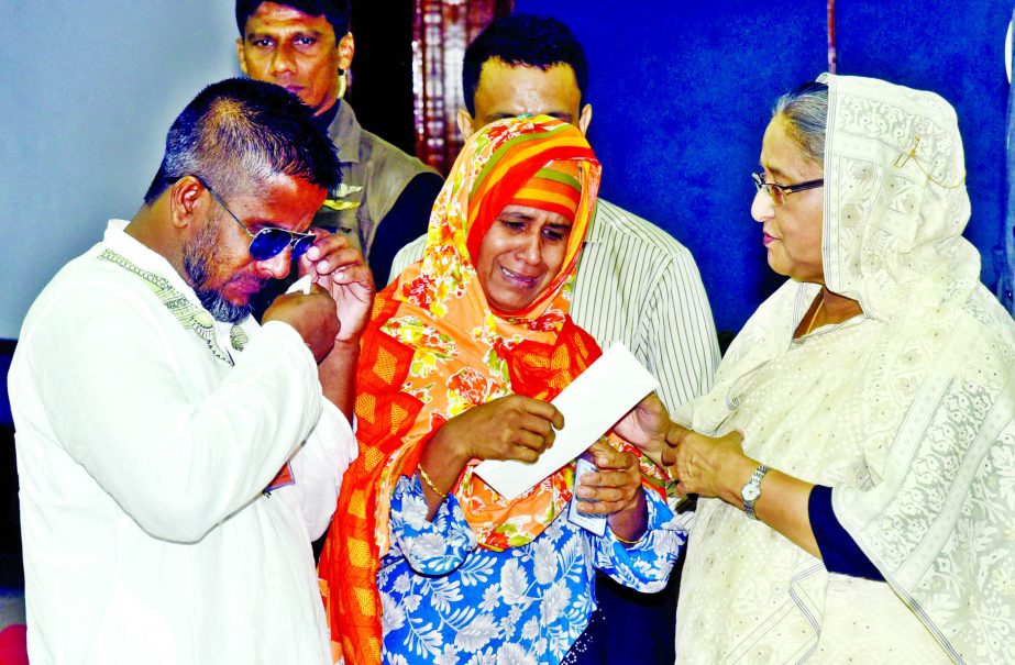 Prime Minister Sheikh Hasina handing over cheques among injured persons and family members of the persons died in the atrocities of BNP and Jamaat at Indurkani of Pirojpur district during anti-govt movement in 2014 and 2015 at her office yesterday.