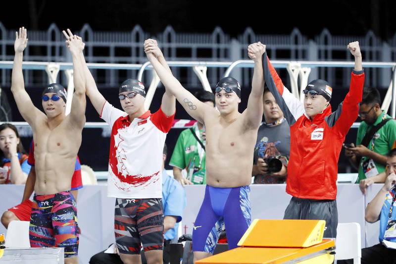 Members of Singapore team wave before the start of Men's 400M Freestyle Relay Swimming final of the 29th South East Asian Games in Kuala Lumpur, Malaysia, Tuesday.