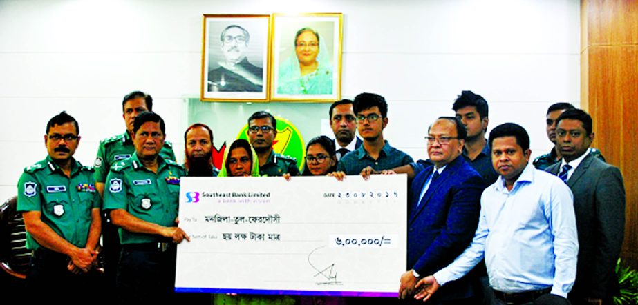 M Kamal Hossain, Managing Director of Southeast Bank Limited, handing over a cheque of Tk 6 Lakh to Monjila-Tul-Ferdousi, wife of late Officer-in-Charge (OC) of Uttarkhan Police Station in presence of under DMP Commissioner Asduzzaman Mia, on Wednesday at