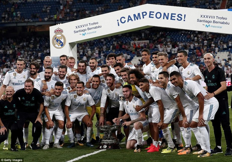 Real Madrid players pose with the Santiago Bernabeu Trophy soccer after beating Fiorentina 2-1 at the Santiago Bernabeu stadium in Madrid, Spain on Thursday.