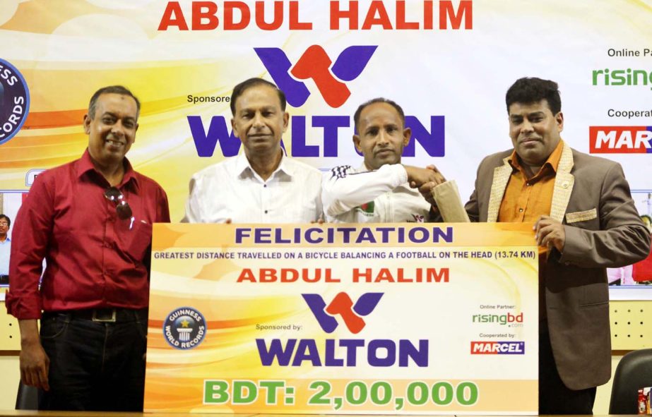 Operative Director (Head of Sports & Welfare Department) of Walton Group FM Iqbal Bin Anwar Dawn (extreme right) handing over a cheque of Taka two lakh to Abdul Halim (second from right) at the conference room of Bangladesh Olympic Association Bhaban on T