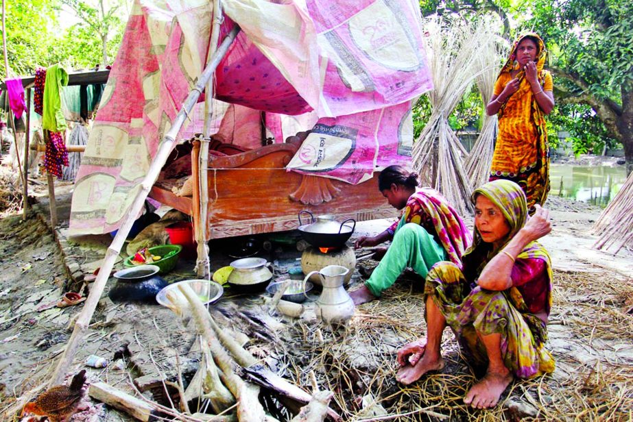 Despite flood water receding in some areas in Jamalpur district victims are passing their days under the open sky with agony. This picture was taken from Islampur area on Friday.