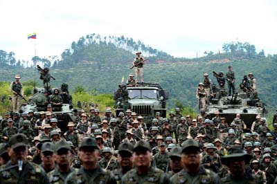 Venezuelan troops in different fatigues and carrying various weapons attend a press conference given by Defence Minister General Vladimir Padrino Lopez.