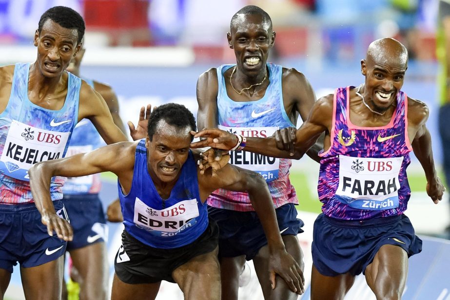 Mo Farah of Britain, right, crosses the finish line to win the Men's 5000m followed by second placed Paul Chelimo of United States, center right, and the falling Muktar Edris of Ethiopia during the Weltklasse IAAF Diamond League international athletics m