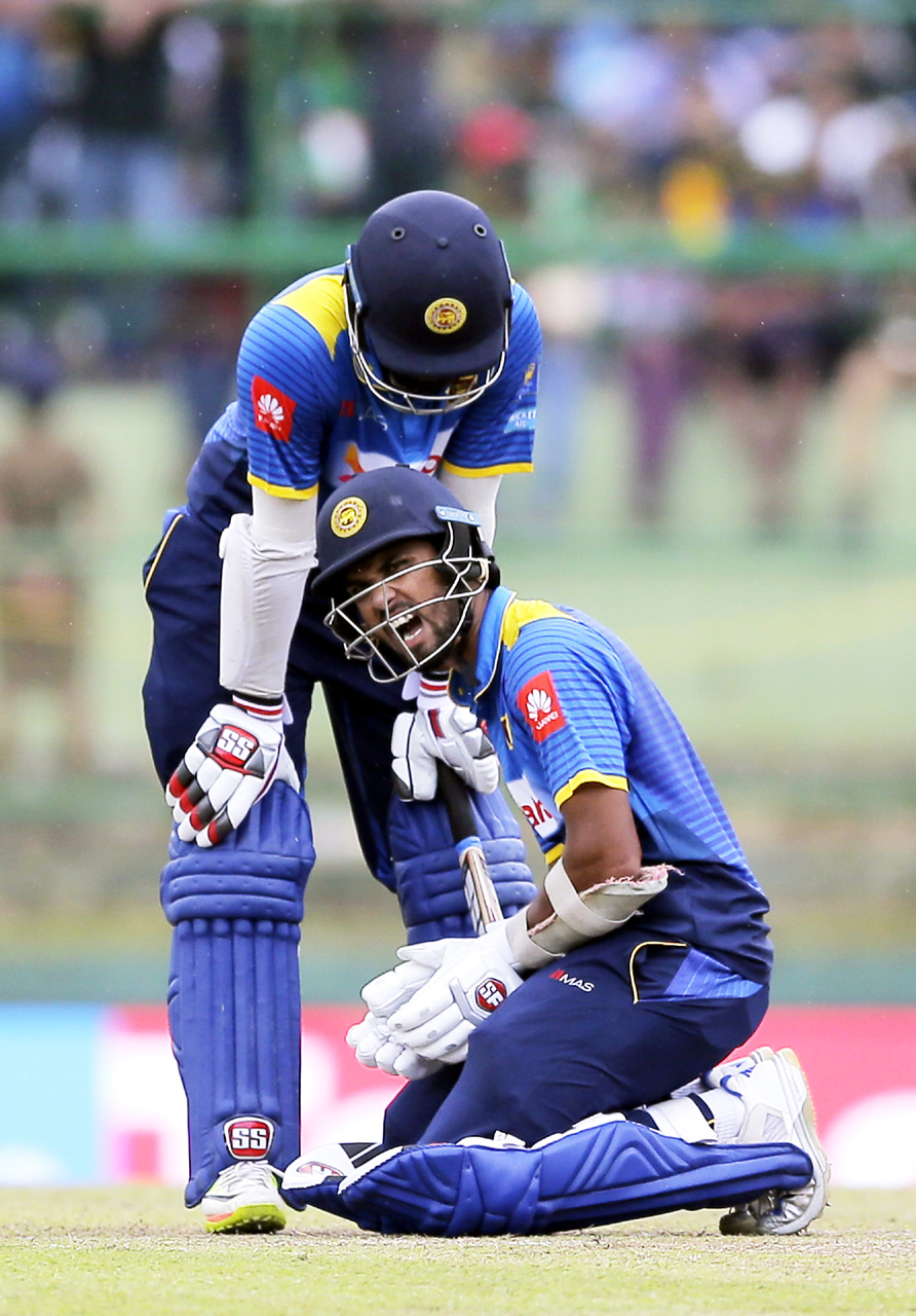 Sri Lanka's Dinesh Chandimal (right) grimaces in pain after he was hit by a delivery bowled by India's Hardik Pandya during their third One-Day International cricket match in Pallekele, Sri Lanka on Sunday.