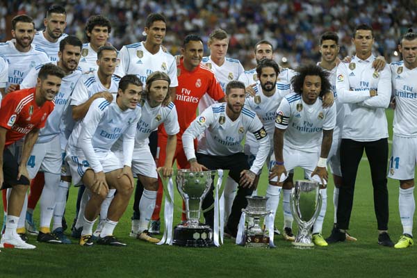 Real Madrid players pose with the Spanish La Liga Cup, Spain's Super Cup and Europe Super Cup prior to a Spanish La Liga soccer match between Real Madrid and Valencia at the Santiago Bernabeu stadium in Madrid on Sunday.