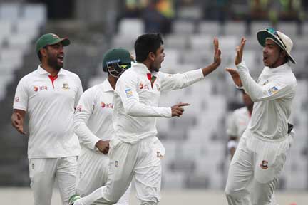 Teammates congratulate Mehedi Hasan Miraz (center) after the dismissal of Australia's Matthew Wade (left) during the second day of their first Test at the Sher-e-Bangla National Cricket Stadium in Mirpur on Monday.