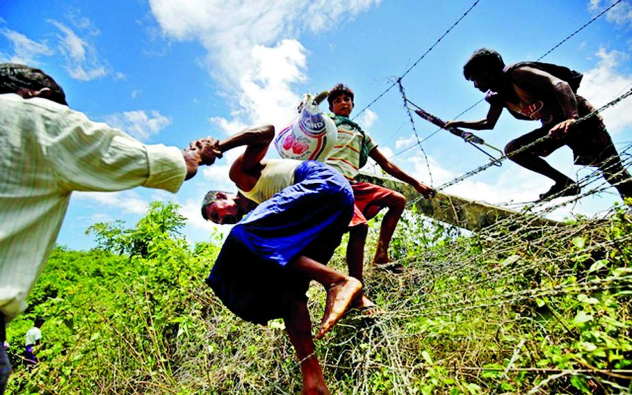Rohingya people cross the border fence to enter Bangladesh border, in Cox's Bazar, on Monday.
