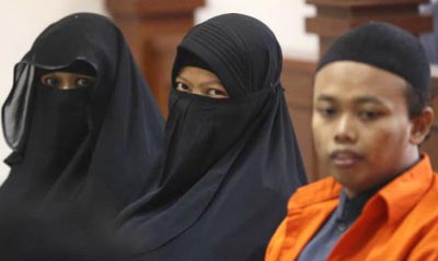 Indonesian militant Dian Yulia Novi (centre) is flanked by her husband Nur Solihin (right) and her recruiter Tutin as they sit on the defendant's bench during their trial hearing at East Jakarta District Court in Jakarta, Indonesia.