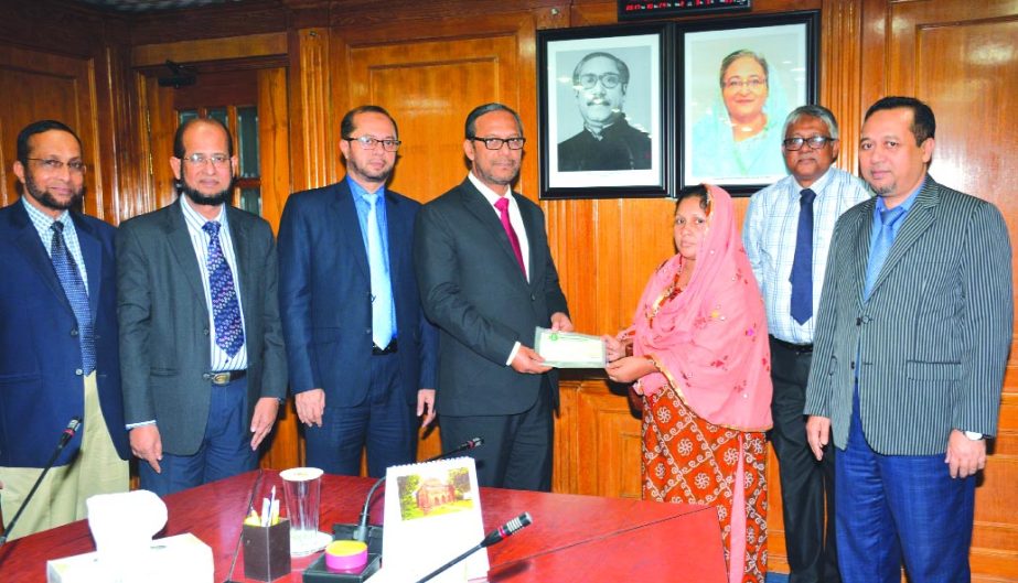 Md. Mahbub ul Alam, Acting Managing Director of Islami Bank Bangladesh Limited, handing over a cheque of Tk 5 lakh to Khadija Begum, widow of Md. Mahbubur Rahman who died of colon cancer as donation at the bank's head office on Thursday. Mohammad Monirul