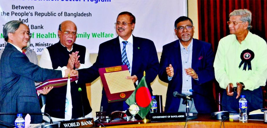 Kazi Shofiqul Azam, Secretary, Economic Relations Division (ERD) under Finance Ministry, and Qimiao Fan, World Bank Country Director for Bangladesh, exchanging an agreement signing documents at ERD on Monday. Under the deal, Bangladesh will receive $515 m