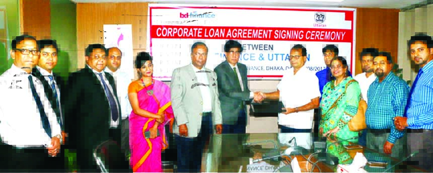 Mohammad Masoom, Managing Director of Bangladesh Finance and Investment Company Limited (BD Finance) and Shahidul Islam, Secretary of Uttaran (an NGO), exchanging agreement signing documents at BD Finance head office in the city on Monday. Under the deal,