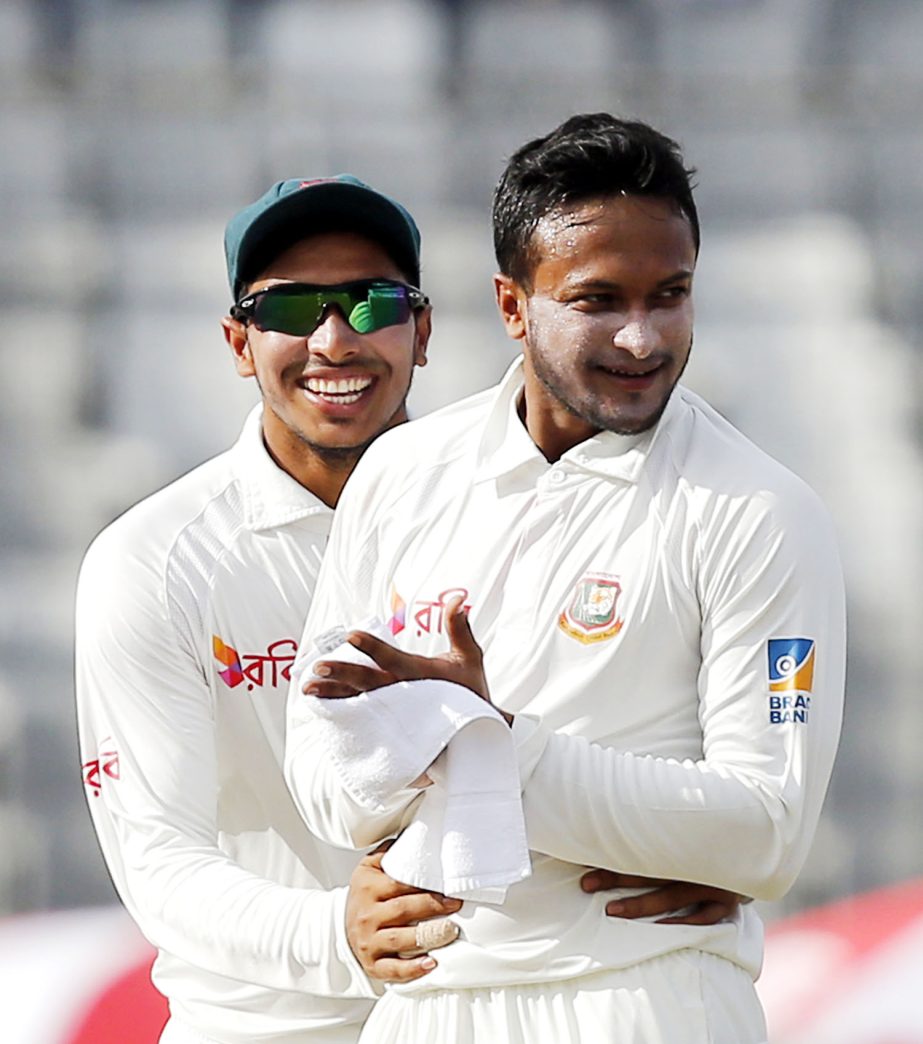 Shakib Al Hasan (right) celebrates with his teammate Soumya Sarkar after the dismissal of Australia's Usman Khawaja during the third day of their first Test cricket match at Sher-e-Bangla National Cricket stadium on Tuesday.