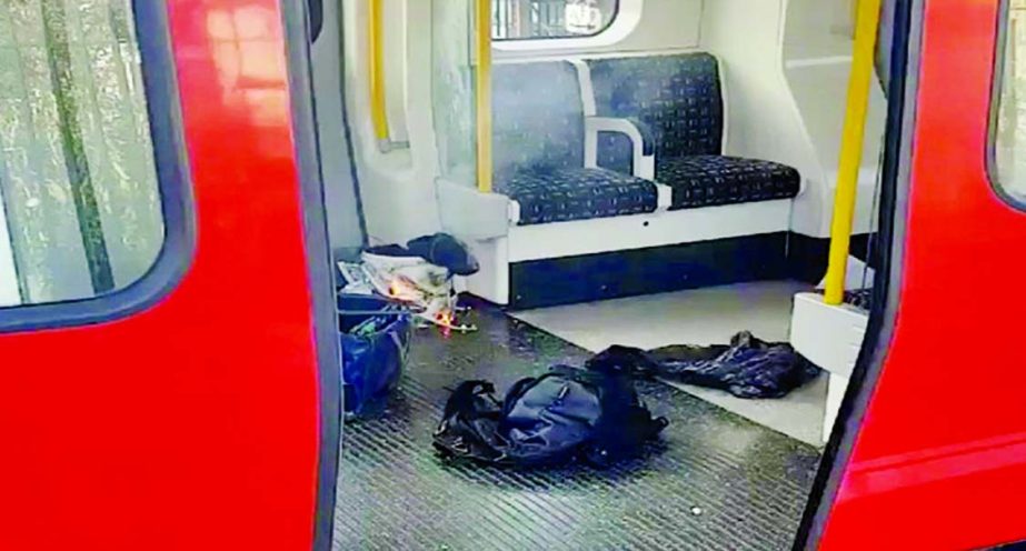 Personal belongings and a bucket with an item on fire inside it are seen on the floor of an underground train carriage at Parsons Green station in London.