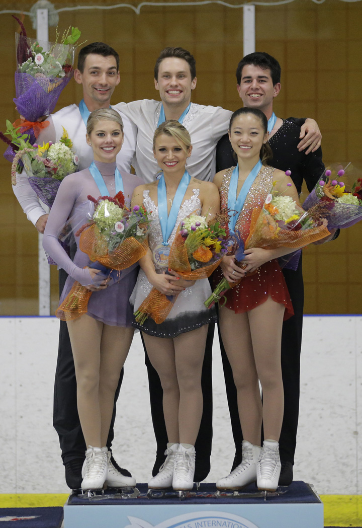 Pairs winners Kirsten Moore-Towers and Michael Marinaro (center) of Canada, stand on the podium with second-place Alexa Scimeca Knierim and Chris Knierim (left) of the United States and third-place Chelsea Liu and Brian Johnson of the United States at the