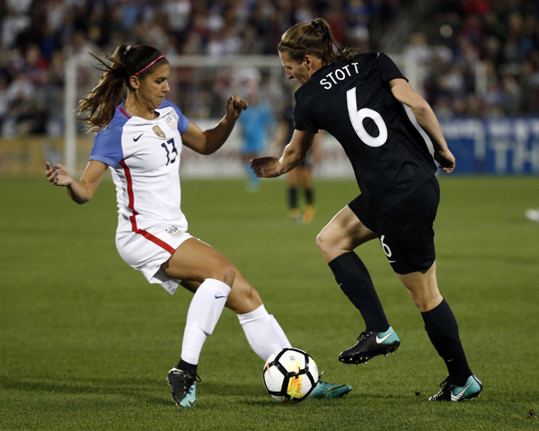 U.S. forward Alex Morgan (13) moves the ball away from New Zealand defender Rebekah Stott during the first half of an international friendly soccer match in Commerce City, Colo. on Friday.