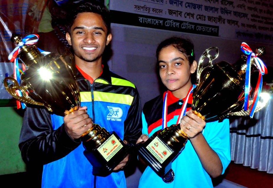 Saida Akter Mou (right) of Bangladesh Ansar & VDP and Rifad Ahmed Sabbir of BKSP pose with their trophies of the girls' singles and boys' singles of the South Bangla Agriculture & Commerce Bank 4th National Junior Table Tennis Championship at the Shahee