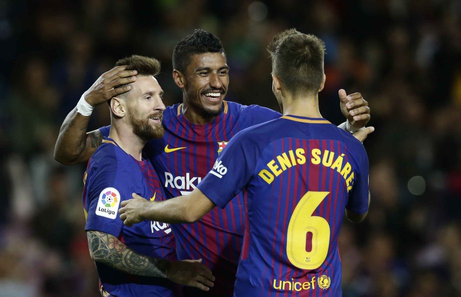 FC Barcelona's Lionel Messi (left) celebrates after scoring with his teammate Paulinho, center, and Denis Suarez during the Spanish La Liga soccer match between FC Barcelona and Eibar at the Camp Nou stadium in Barcelona, Spain on Tuesday.