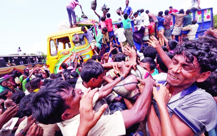 Rohingya refugees scuffle as aid was distributed in Cox's Bazar on Saturday.