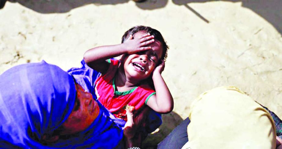 A Rohingya refugee child reacts as people queue for aid in a camp in Coxâ€™s Bazar on Friday. Reuters photo