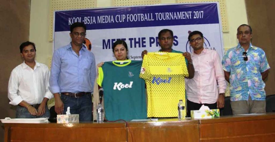 Senior Marketing Manager of Square Toiletries Limited Jesmin Zaman and Head Coach of Bangladesh National Women's Football team Golam Rabbani Choton showing the jerseys of Kool-BSJA Media Cup Football Tournament, at the Dutch-Bangla Bank Auditorium of Ban