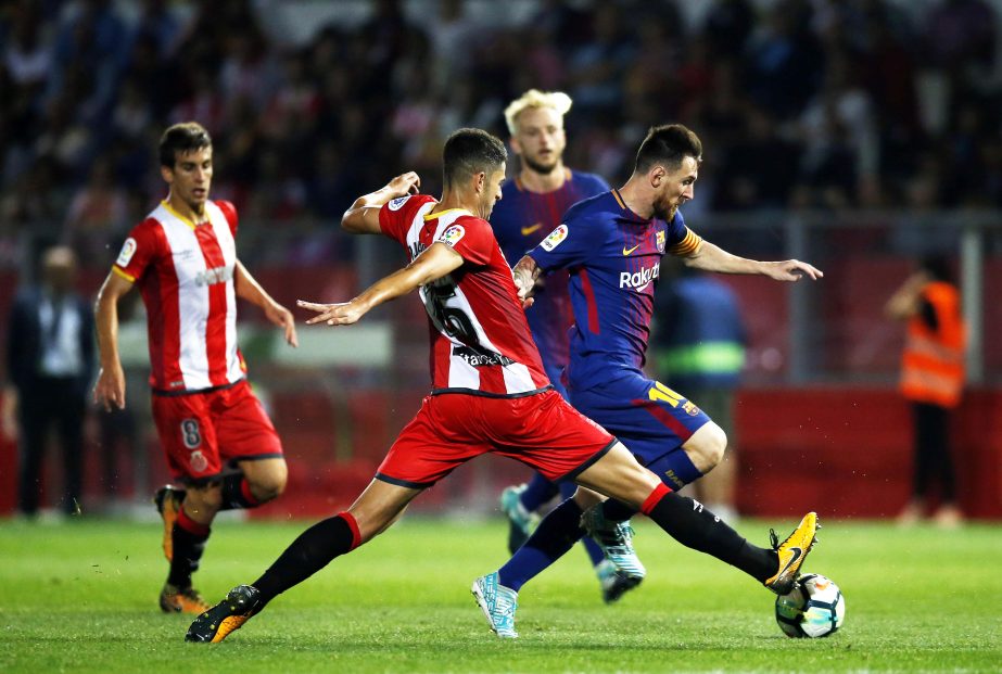 FC Barcelona's Lionel Messi (right) duels for the ball against Girona's Juanpe Ramirez during the Spanish La Liga soccer match between Girona and FC Barcelona at the Montilivi stadium in Girona, Spain on Saturday.