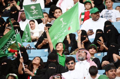 A boy waves a flag with a caption reading in Arabic "the nation is in our hearts"" at a stadium in the Saudi capital Riyadh on Saturday at an event commemorating the Kingdom's founding anniversary."