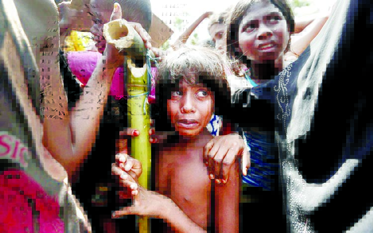 Two Rohingya refugee girls react as some others scuffle while waiting to receive aid in Cox's Bazar on Monday.