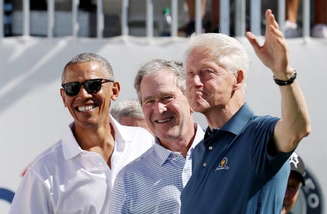 Former U.S. Presidents Barack Obama, George W. Bush and Bill Clinton smile during the first round foursomes match of The President's Cup golf tournament at Liberty National Golf Course.