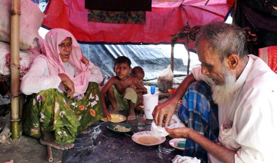 A Rohingya family taking food at a camp . This picture was taken yesterday.