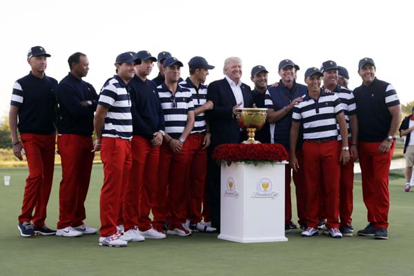 President Donald Trump (center) poses with the U.S. Team after presenting them the winner's trophy following the final round of the Presidentâ€™s Cup golf tournament at Liberty National Golf Club in Jersey City, N.J. on Sunday.