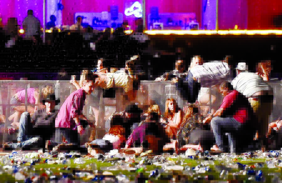 People scramble over barriers to get to safety as the gunfire rages on at the Las Vegas event.