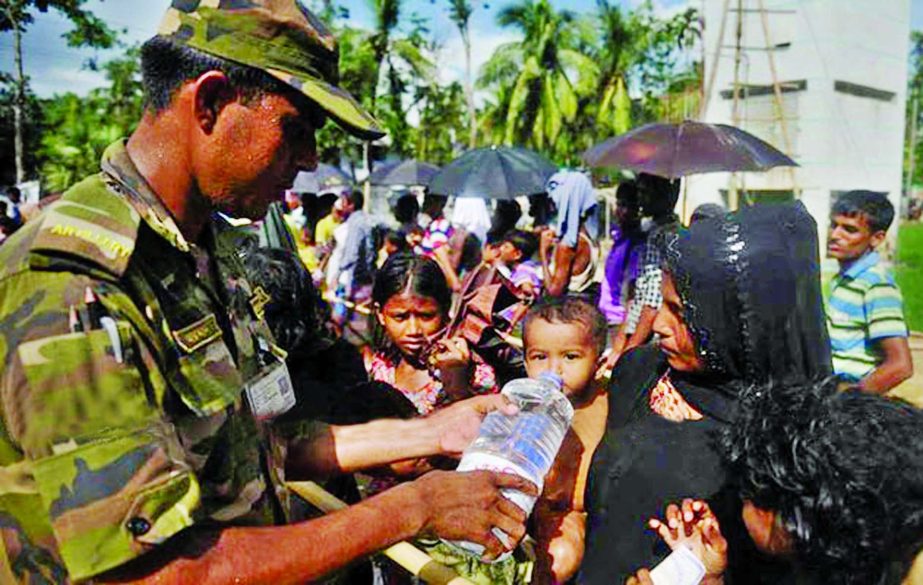 Members of Bangladesh Armed Forces raising their hands to treat the Rohingya children at the camp. This photo was taken from Kutupalong camp in Cox's Bazar on Tuesday.