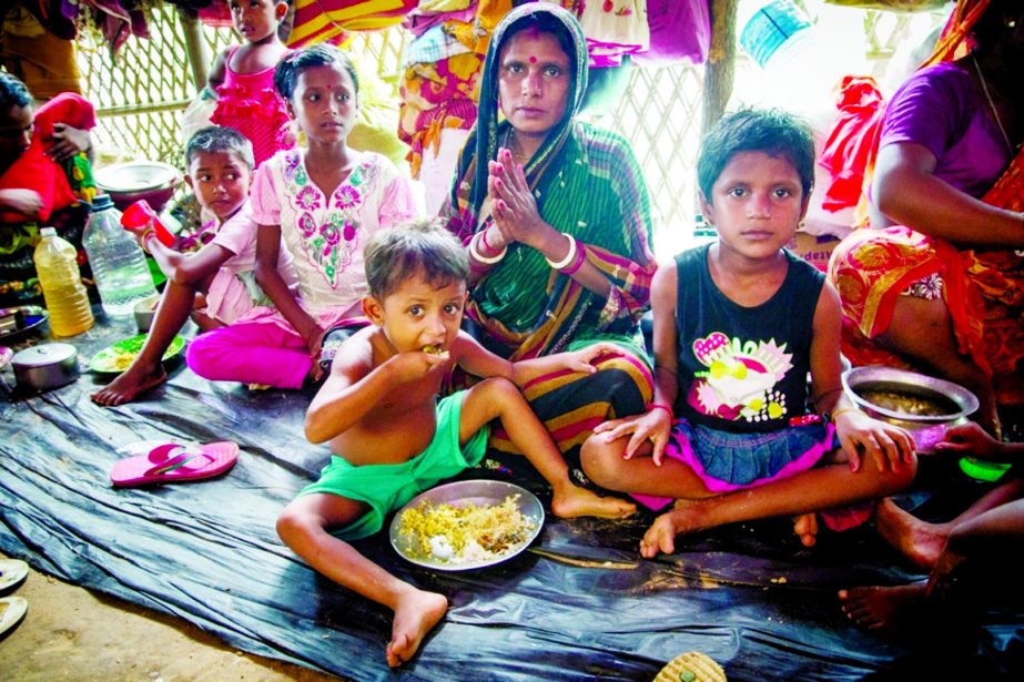 Onu Bala (30) and her three children eat a meal at Hindu Para village, Kutupalang in Cox's Bazar. Onu, a Hindu, escaped when masked men invaded her village in the north of Rakhine state in Myanmar and began setting fire to houses.