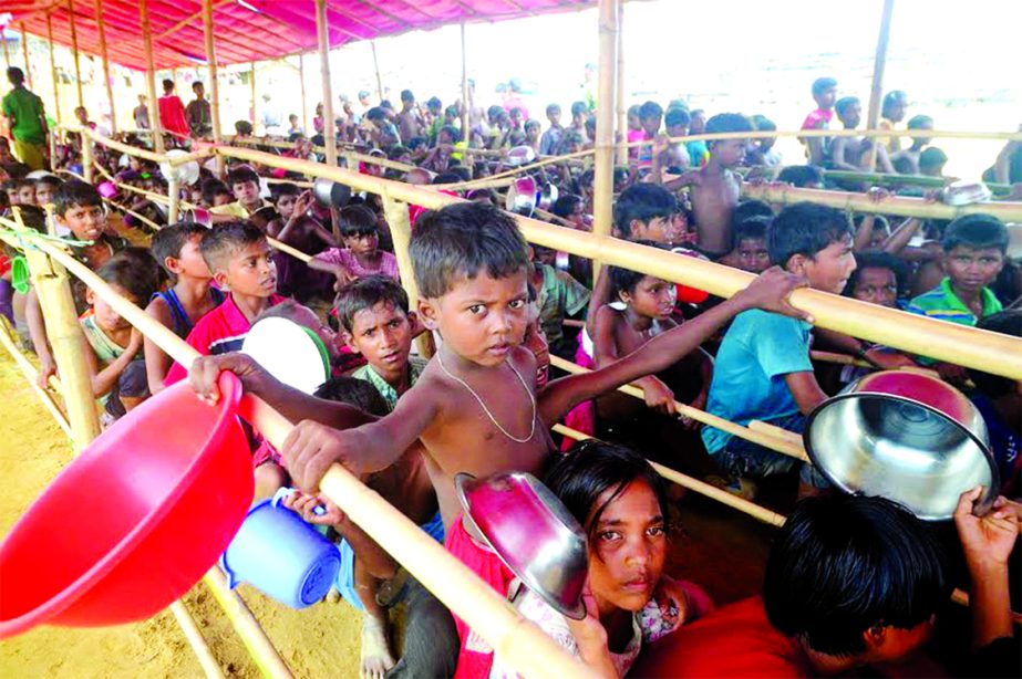 Rohingya children are waiting in the long queue with empty bowls for food. This photo was taken from Jamtola at Ukhiya Upazila in Cox's Bazar district on Friday.