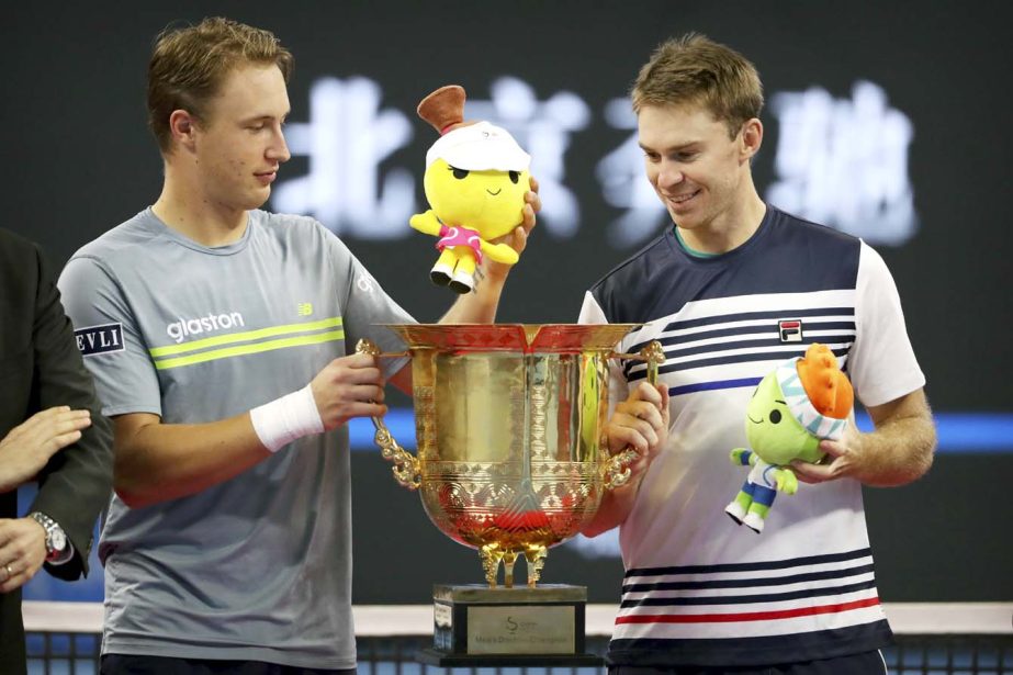 Henri Kontinen of Finland (left) and John Peers of Australia pose for photos with the winners' trophy after beating John Isner and Jack Sock of the United States in the men's doubles championship in the China Open tennis tournament at the Diamond Court