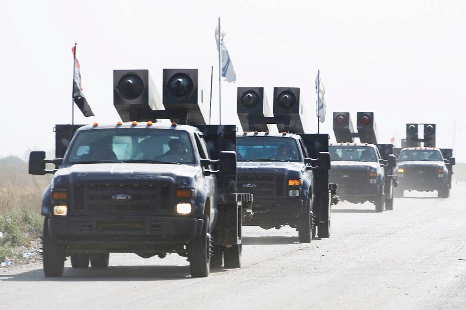 Iraqi forces drive towards Kurdish peshmerga positions on the southern outskirts of Kirkuk city on Saturday.