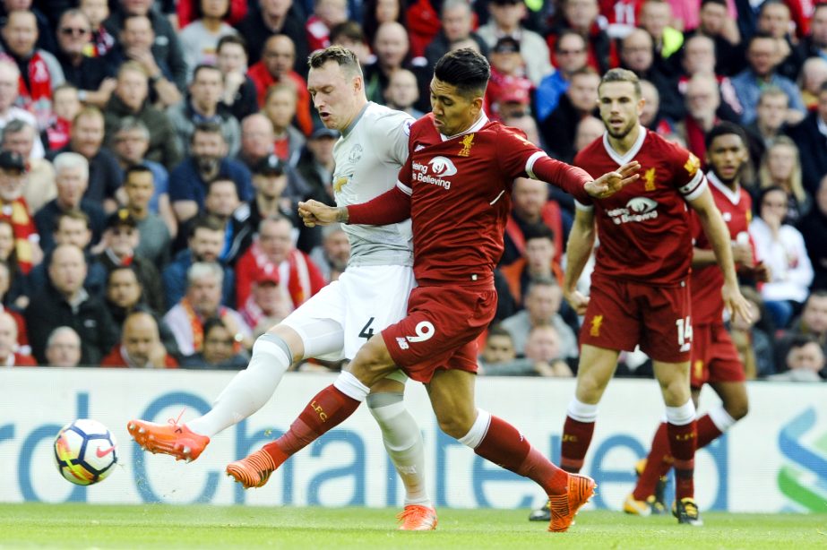 From (left) Manchester United's Phil Jones and Liverpool's Roberto Firmino battle for the ball during the English Premier League soccer match between Liverpool and Manchester United at Anfield, Liverpool, England on Saturday.