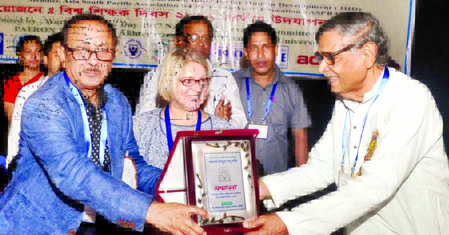 Primary and Mass Education Minister Mostafizur Rahman handing over citation to Bishwa Sahitya Kendra President Prof Abdullah Abu Sayeed for his role in education at TSC auditorium of Dhaka University on Tuesday in observance of World Teachers' Day.