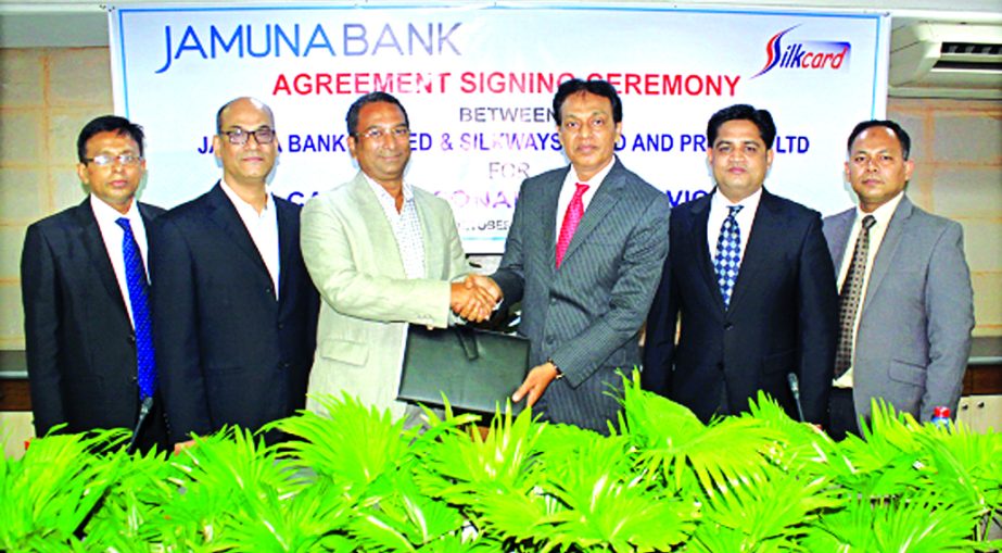 AKM Saifuddin Ahamed, Deputy Managing Director of Jamuna Bank Limited and Sk Farid Ahmed Manik, Managing Director of Silkways Card and Printing Limited (Silkcard) exchanging an agreement signing documents at the bank's head office in the city recently. U