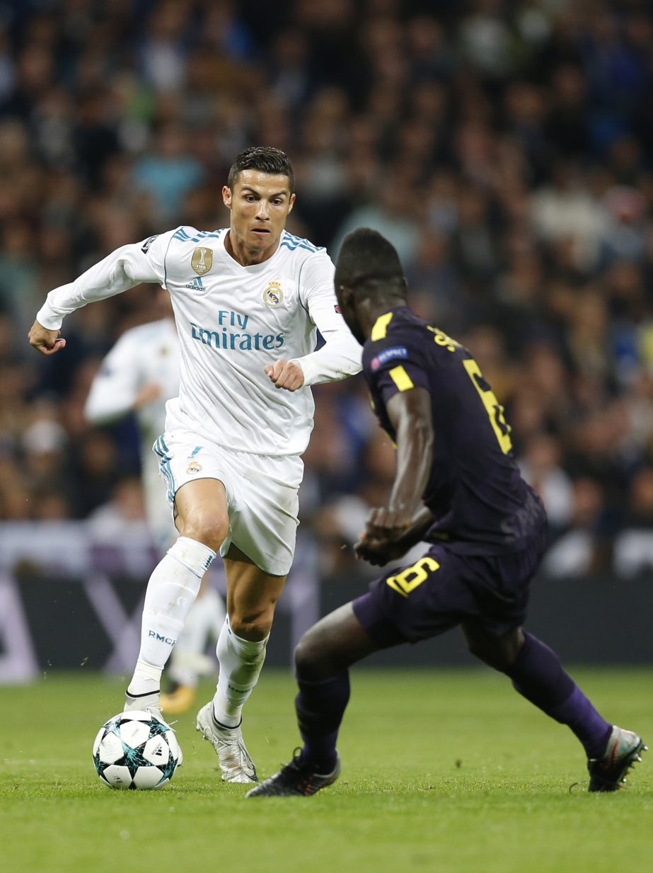 Real Madrid's Cristiano Ronaldo (left) run with the ball against Tottenham's Davinson Sanchez during a Group H Champions League soccer match between Real Madrid and Tottenham Hotspur at the Santiago Bernabeu stadium in Madrid on Tuesday.