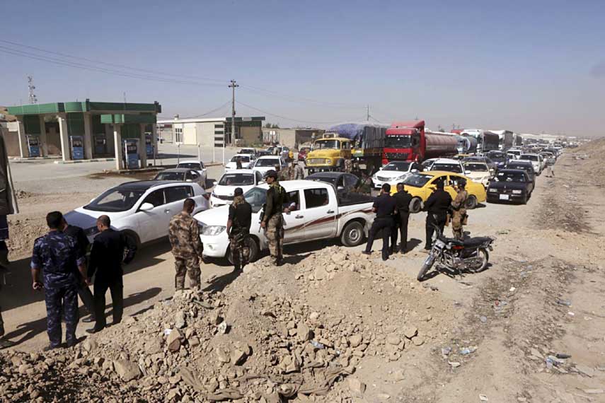 Federal security forces and local police stand guard in the northern entrance of Kirkuk while people returning back to Kirkuk, 290 kilometers (180 miles) north of Baghdad on Tuesday.