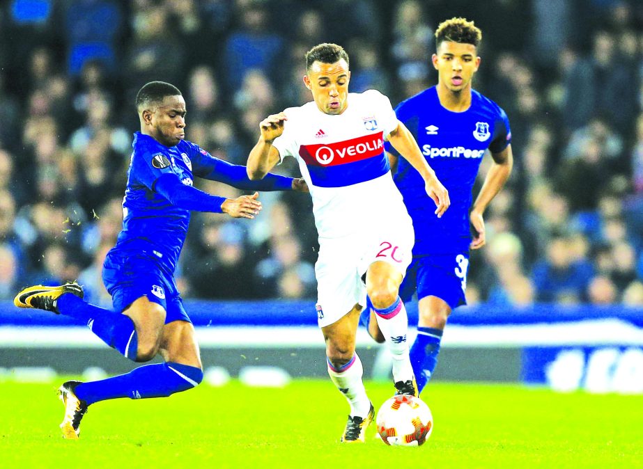 Everton's Ademola Lookman (left) jumps into Lyon's Fernando Marcal (center) during a Group E Europa League soccer match between Everton F.C. and Olympique Lyon at Goodison Park Stadium, Liverpool, England on Thursday.