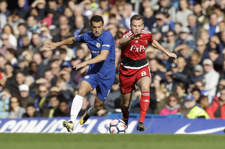 Chelsea's Pedro (left) competes for the ball with Watford's Tom Cleverley during the English Premier League soccer match between Chelsea and Watford at Stamford Bridge stadium in London on Saturday.