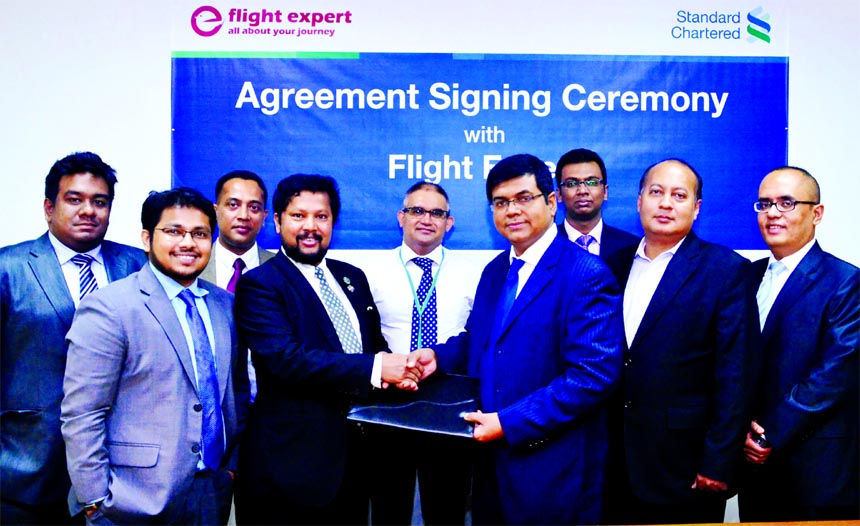 Makam E Mahmud Billah, Head of Retail Products and Segments, Standard Chartered Bank Bangladesh and MA Rashid Shah Shamrat, Chairman, Makkah Group of Companies, exchanging MoU signing documents at its head office in the city on Sunday. Under the deal, Mak
